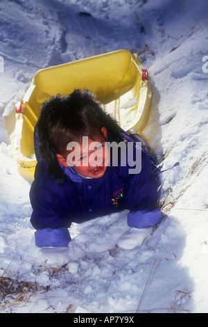 Tre anni ragazzo bianco piange dopo la caduta del suo sled nella neve. Foto Stock