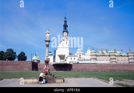 Donna che mantiene i mazzi di fiori nella parte anteriore della statua della Vergine Maria in Slesia Polonia Europa Foto Stock
