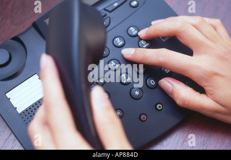 Close-up di donna con le mani in mano la composizione del numero di telefono fisso Foto Stock