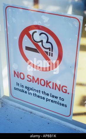 Segno sulla finestra o porta in luce della sera affermando con icona fumare non è contro la legge di fumare in questi locali Foto Stock