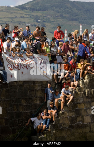 La folla di popolo basco guarda Sokamuturra bull in esecuzione evento da sulla parete del porto di Puerto Viejo, Algorta Paese Basco in Spagna Foto Stock