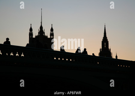 Pedoni sul Westminster Bridge stagliano contro le Case del Parlamento, Londra Foto Stock