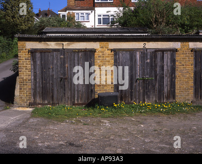 Lock up garage con porte in legno e una TV rotta sul terreno Foto Stock