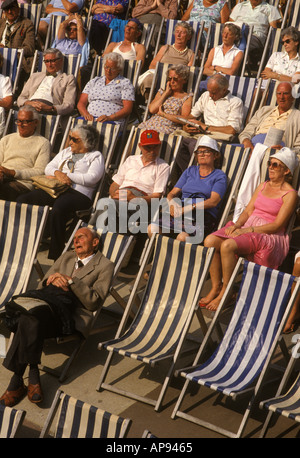 Pensionati di vecchiaia, le persone anziane godono del sole estivo che dorme sulle sdraio di Eastbourne, Regno Unito. 1980, 80 HOMER SYKES. Foto Stock