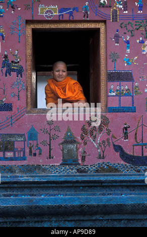 Monaco novizio nella finestra del mosaico decorato tempio di Wat Xieng Thong Luang Prabang s più famoso monastero Laos Foto Stock