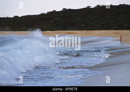 Uomo sulla spiaggia cercando onde giganti Foto Stock