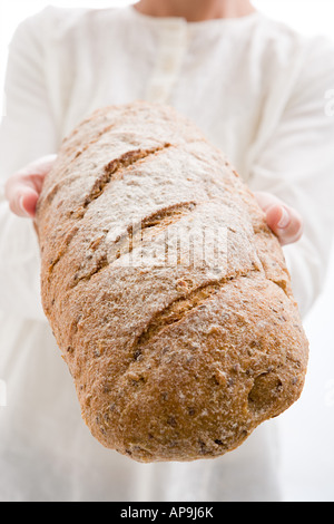 Donna che mantiene pagnotta di pane Foto Stock
