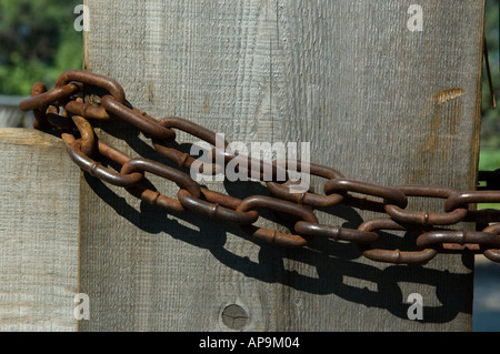 Catene di trasmissione avvolto intorno a posti di legno di una porta Foto Stock