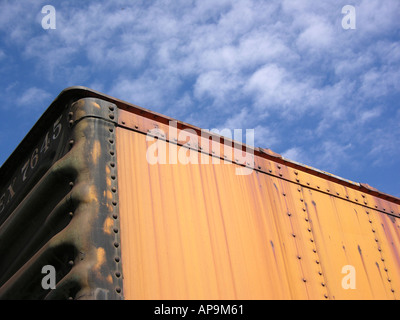 Abbandonato il treno auto si siede nel cantiere ferroviario con un luminoso cielo blu sopra. Foto Stock