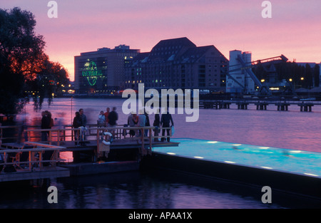 Berlino. Badeschiff an der Arena am Abend. Badeschiff in serata. La gente di nuoto, rilassarsi e godersi il tramonto e lo skyline. Foto Stock