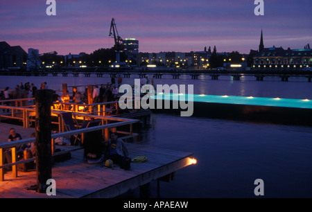 Berlino. Badeschiff an der Arena am Abend. Badeschiff in serata. La gente di nuoto, rilassarsi e godersi il tramonto e lo skyline. Foto Stock