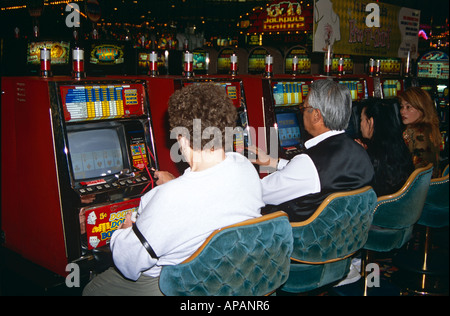 Le persone a giocare a poker slot machines in un casinò di Las Vegas, Nevada, STATI UNITI D'AMERICA Foto Stock