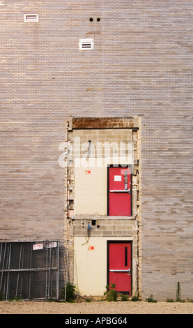 Mattone di Edificio industriale con due porte di rosso per nulla nel lato sulla parte superiore di ogni altro con questo modo alle insegne Foto Stock