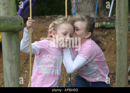 Sorelle sussurra all'altra. Foto Stock