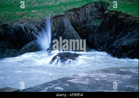 Onde che si infrangono sulle rocce a Pothgain Pembrokeshire Wales UK Foto Stock