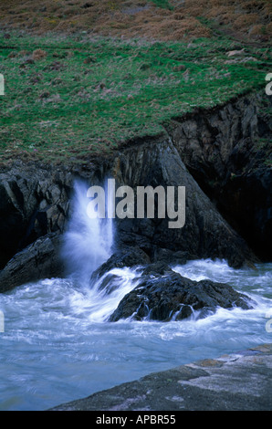 Onde che si infrangono sulle rocce a Pothgain Pembrokeshire Wales UK Foto Stock