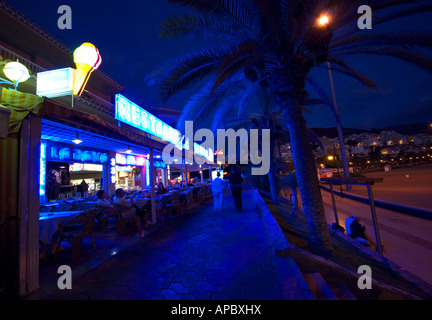 Come la sera arriva i ristoranti iniziano a riempirsi lungo la Playa de las vistas spiaggia di Los Cristianos, Tenerife, Spagna Foto Stock
