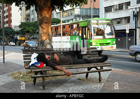 Senzatetto di dormire su una panchina nel centro di Sao Paulo, Brasile Foto Stock
