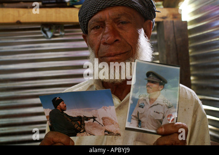 Il vecchio uomo in un rifugio holding fotografie di suo figlio che hanno trovato la morte nel sisma, Sarash Village, Manshera, NWFP, Pakistan Foto Stock