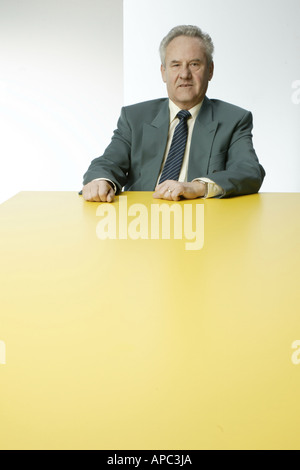 Imprenditore maturo seduti dietro un tavolo Foto Stock