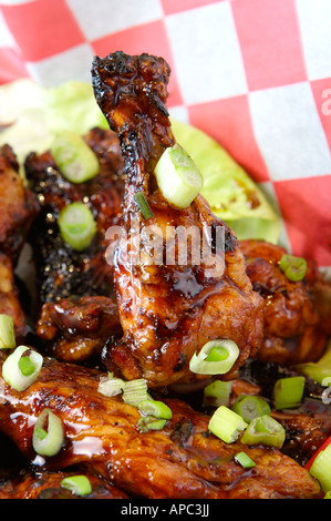 Ali di pollo con scalogno in un cestello Foto Stock