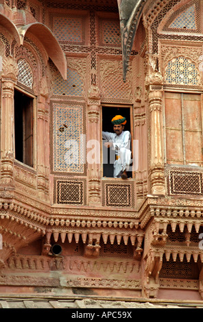 Indian uomo in piedi su una finestra all'interno del Meherangarh Fort di Jodhpur, India Foto Stock