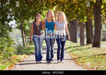 Tre giovani donne a piedi attraverso un parco Foto Stock