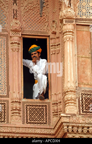 Indian uomo in piedi su una finestra all'interno del Meherangarh Fort di Jodhpur, India Foto Stock