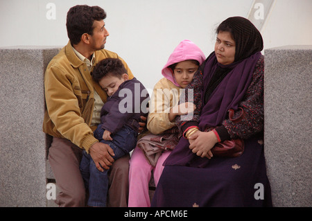 Famiglia asiatica di gruppo in attesa di riposo dormire in al South Bank di Londra. Foto Stock