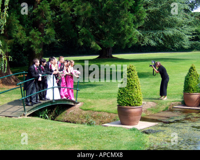 Novelli sposi in posa per le loro foto del matrimonio con la loro miglior uomo e damigelle Foto Stock