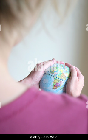 Donna che mantiene globe - tutto il mondo nelle sue mani Foto Stock