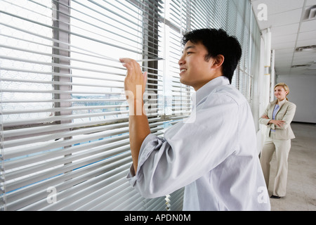 Due imprenditori di guardare attraverso una finestra. Foto Stock