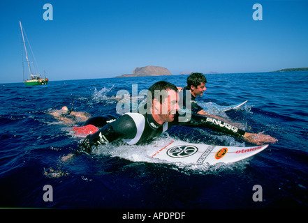 Surfers pagaiando dal loro yacht in mare delle isole Canarie, Spagna, Foto Stock