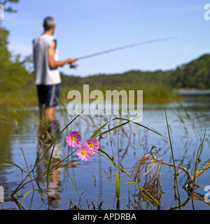 L uomo è la pesca nello stagno sulla mattina di sole Foto Stock