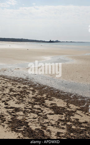 Distante Rocco torre vista su St Ouen's beach in Jersey Foto Stock