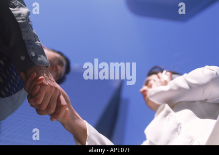 Imprenditore e la donna si stringono la mano sotto i grattacieli della città Foto Stock