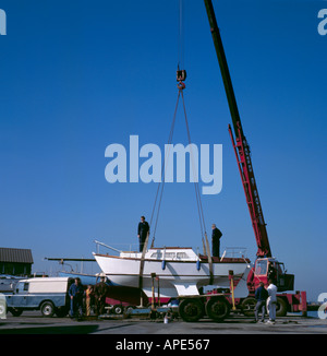 Piccolo keeled sentina yacht essendo preparato per il sollevamento da un mobile gru idraulica in un cantiere navale, Grimsby, Humberside, Inghilterra, Regno Unito. Foto Stock