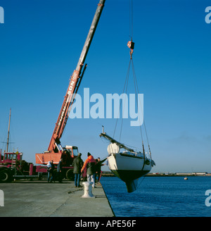 Yacht che viene sollevato da un mobile gru idraulica in cantiere, Grimsby, Humberside, Inghilterra, Regno Unito. Foto Stock