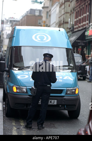 Un vigile emette i biglietti per il parcheggio di un furgone in Soho Londra Inghilterra REGNO UNITO Foto Stock