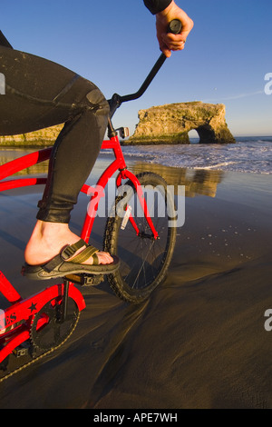 Un close-up di un uomo su un cruiser bike sulla spiaggia di ponti naturali Parco dello stato nei pressi di Santa Cruz in California Foto Stock