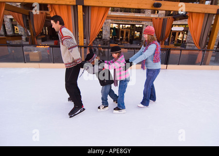 Una famiglia pattinaggio sul ghiaccio at Northstar ski resort vicino al lago Tahoe in California Foto Stock