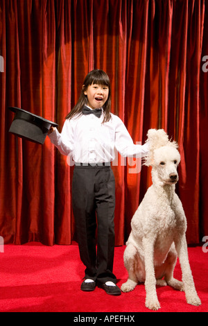 Ragazza asiatica con top hat e cane sul palco Foto Stock