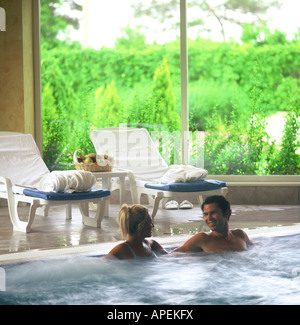 Giovane si rilassa nella vasca idromassaggio Foto Stock