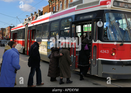 I passeggeri si sono schierate per ottenere sulla TTC Regina tram a Toronto in inverno Foto Stock