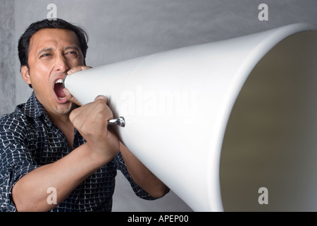 Ritratto Latino uomo grida attraverso il megafono Foto Stock