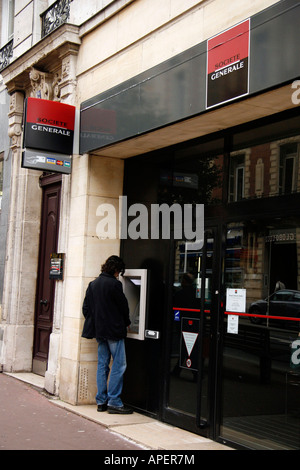 Un uomo preleva denaro da un Societe Generale bancomat in Rouen Senna Marittima Francia Foto Stock