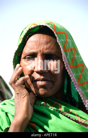 Un indiano donna tribale in un sari verde contiene la sua mano contro il suo volto Ottobre 2007 India Foto Stock