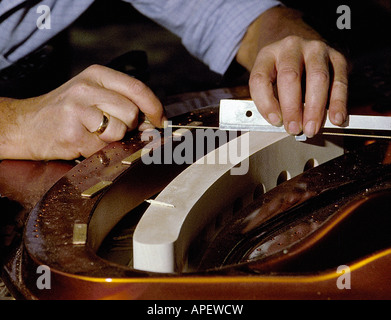 Piano tecnico le mani di close-up di stringa di allineamento nel telaio di pianoforte. (Al pianoforte Bösendorfer fabbrica, Vienna, Austria). Foto Stock