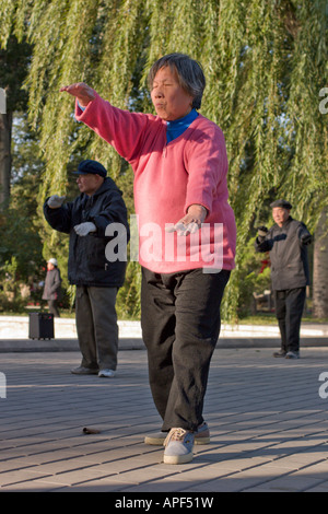 Pechino, una donne nel parco Ritan facendo esercizi di taichi Foto Stock