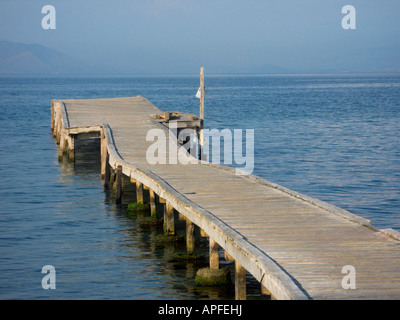 Concludi con la vista di un molo vuoto in legno che sporge nell'Adriatico a Messongi, Corfù, in una tranquilla giornata estiva Foto Stock